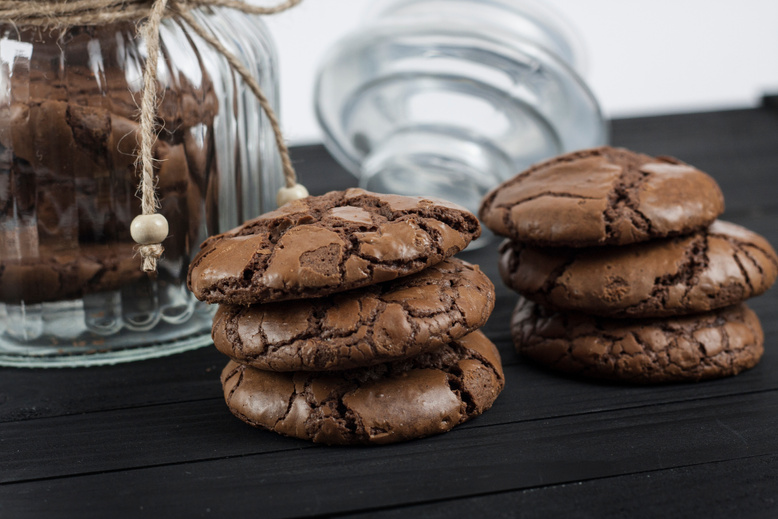 Black Brownie Cookies on a black table and glass jar